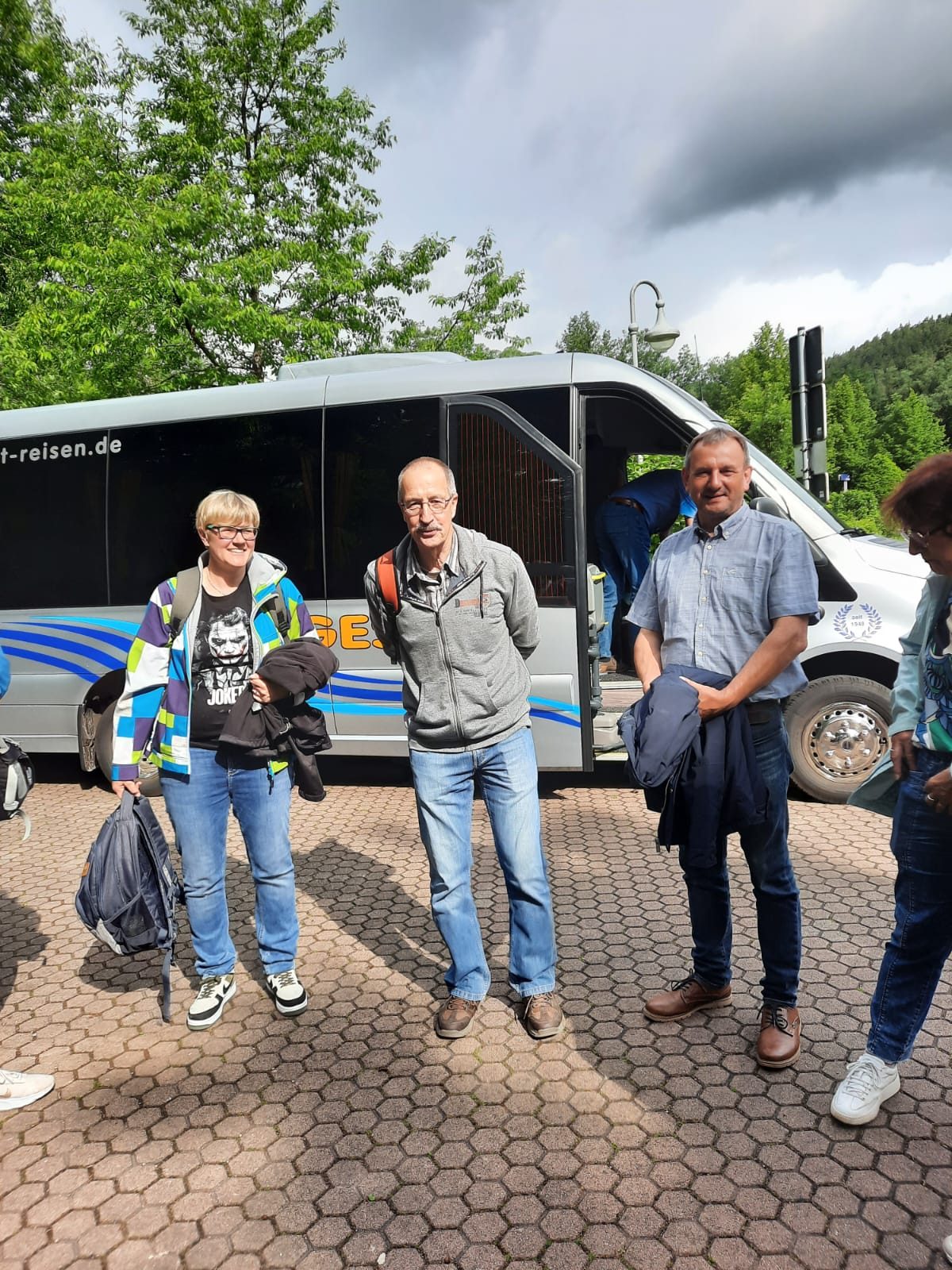 Drei Vereinsmitglieder vor dem Reisebus
