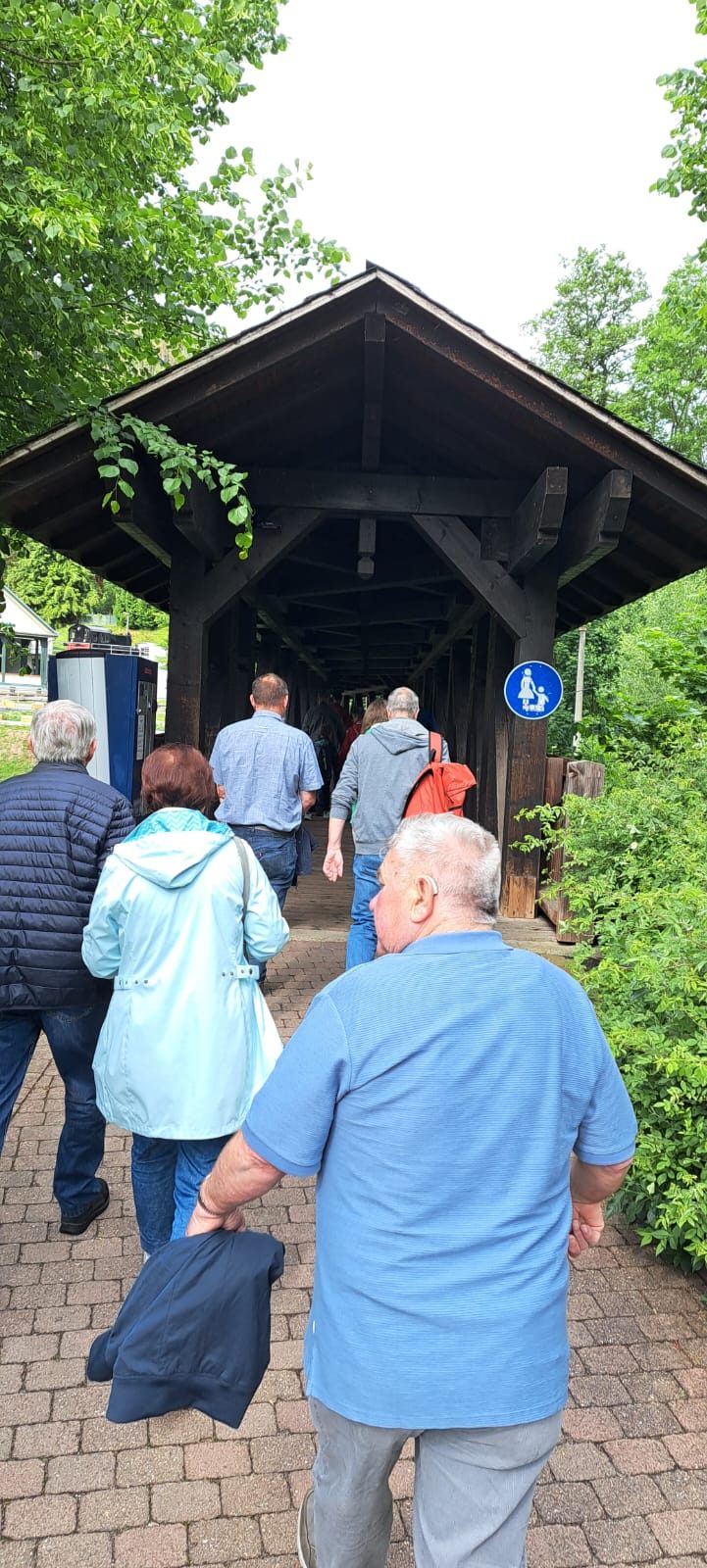 Gruppe geht durch einen überdachten Holzsteg